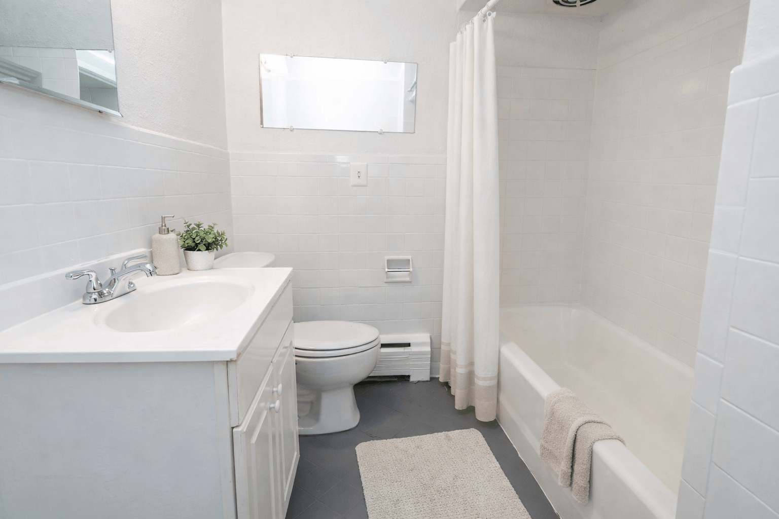 A white bathroom with a toilet, sink, and bathtub.